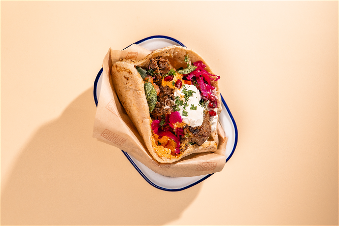Pita pastrami van wild met rucola, piccalilly en granaatappel van Sababa
